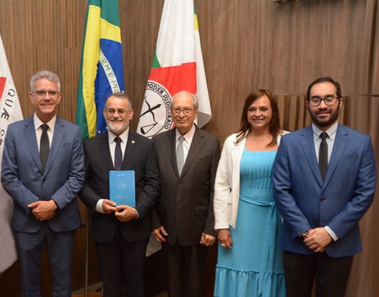 Descrição da imagem: à frente das bandeiras de Minas Gerais, do Brasil e do Poder Judiciários encontram-se posicionados da esquerda para a direita: Carlos Márcio de Souza Macedo (Juiz Auxiliar da 2ª Vice-Presidência do Biênio 2022/2024), Renato Dresh (Desembargador 2º Vice-Presidente e Superintendente da EJEF à época) Humberto Theodoro Júnior Desembargador aposentado do TJMG), Meire Furbino (servidora da COJUR/TJMG) e Thiago Israel Simões Doro Pereira (Diretor Executivo da DIRGED)